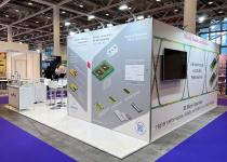 Murata stand, space with no walls, Meeting room with TVs on walls, reception counters and table/chairs